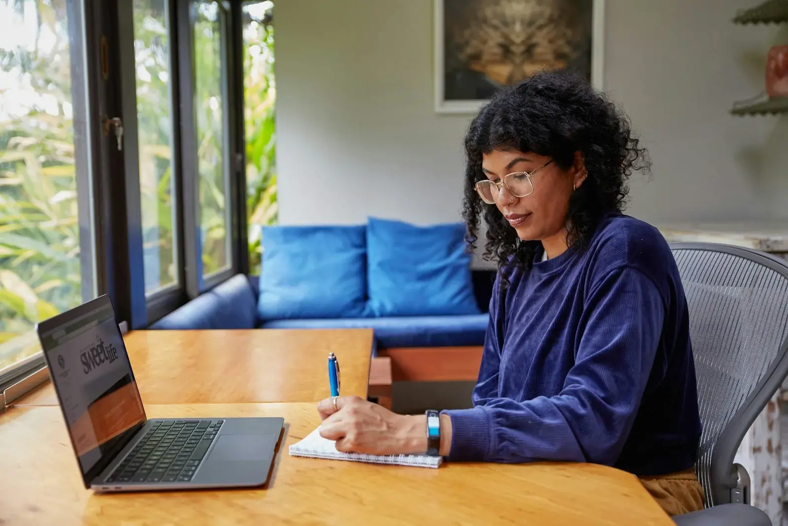 Mujer trabaja en su laptop en casa configurando su tienda online