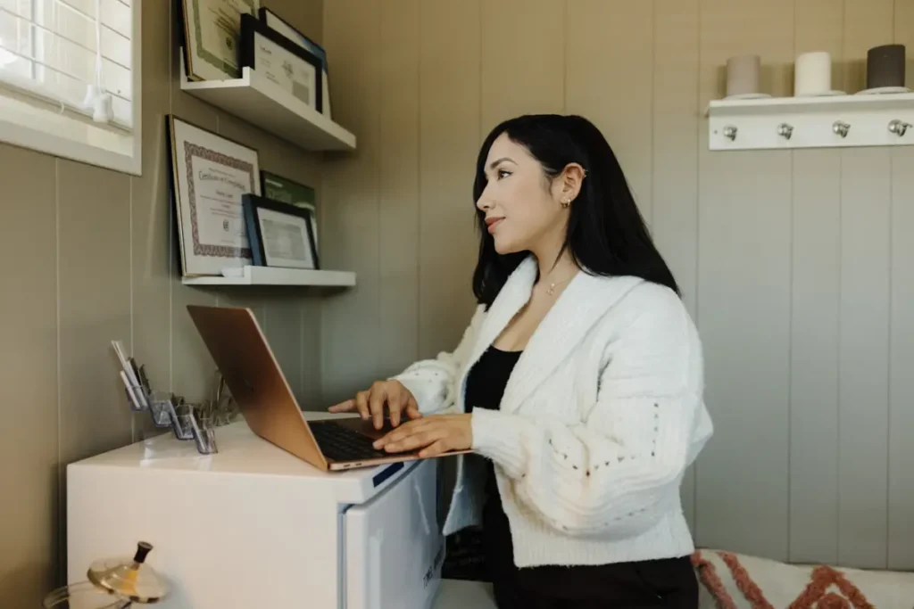 Dueña de un negocio pequeño usando su laptop dentro de su local