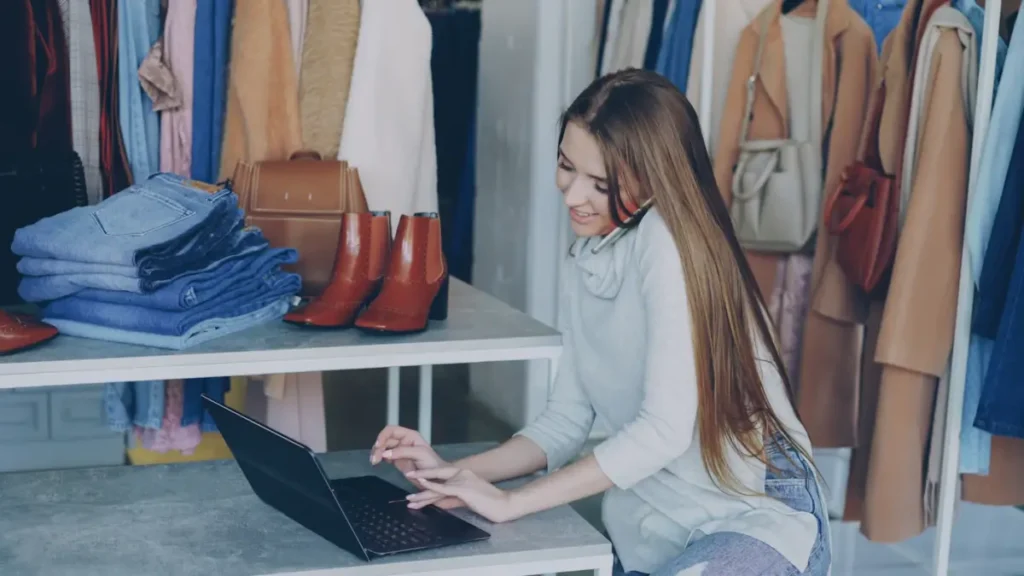 Dueña de una tienda de ropa atendiendo una llamada con su laptop