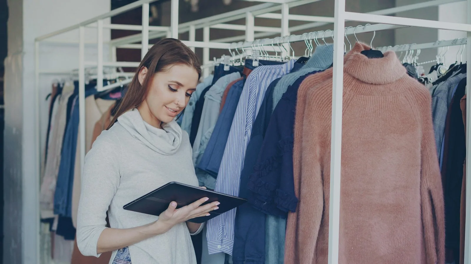 Dueña de una tienda de ropa revisando su negocio en una tablet