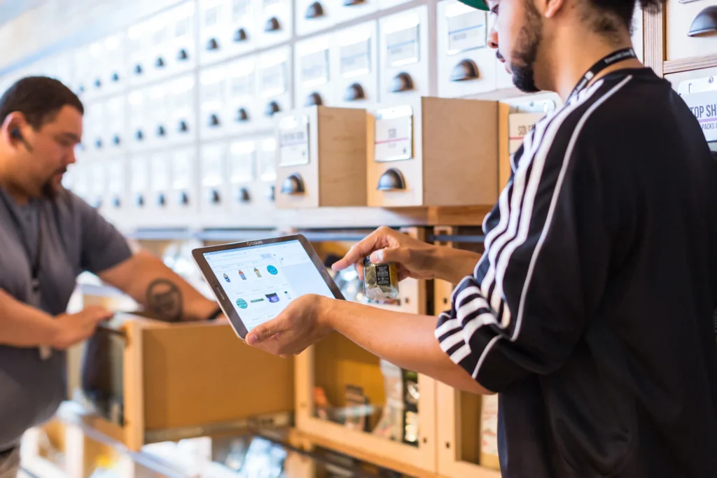 Dos personas revisando inventario con una tablet en una bodega, operación de una tienda online