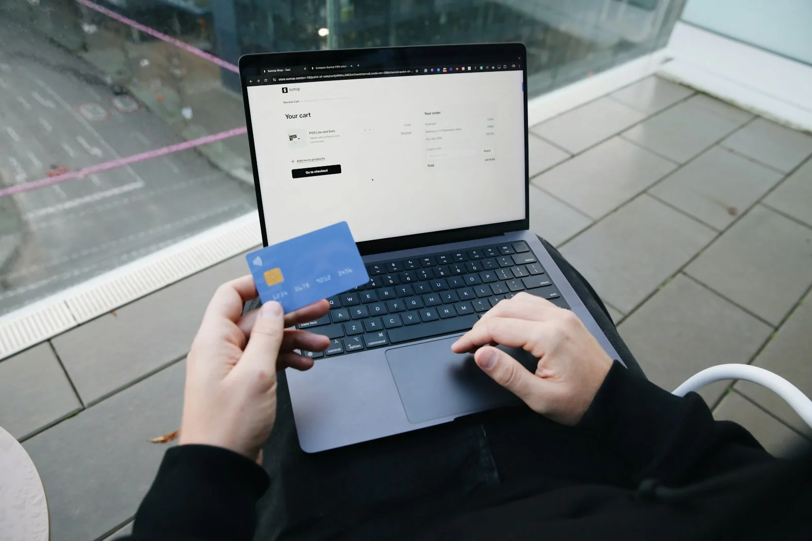 Persona paga una compra online con tarjeta de crédito desde su laptop