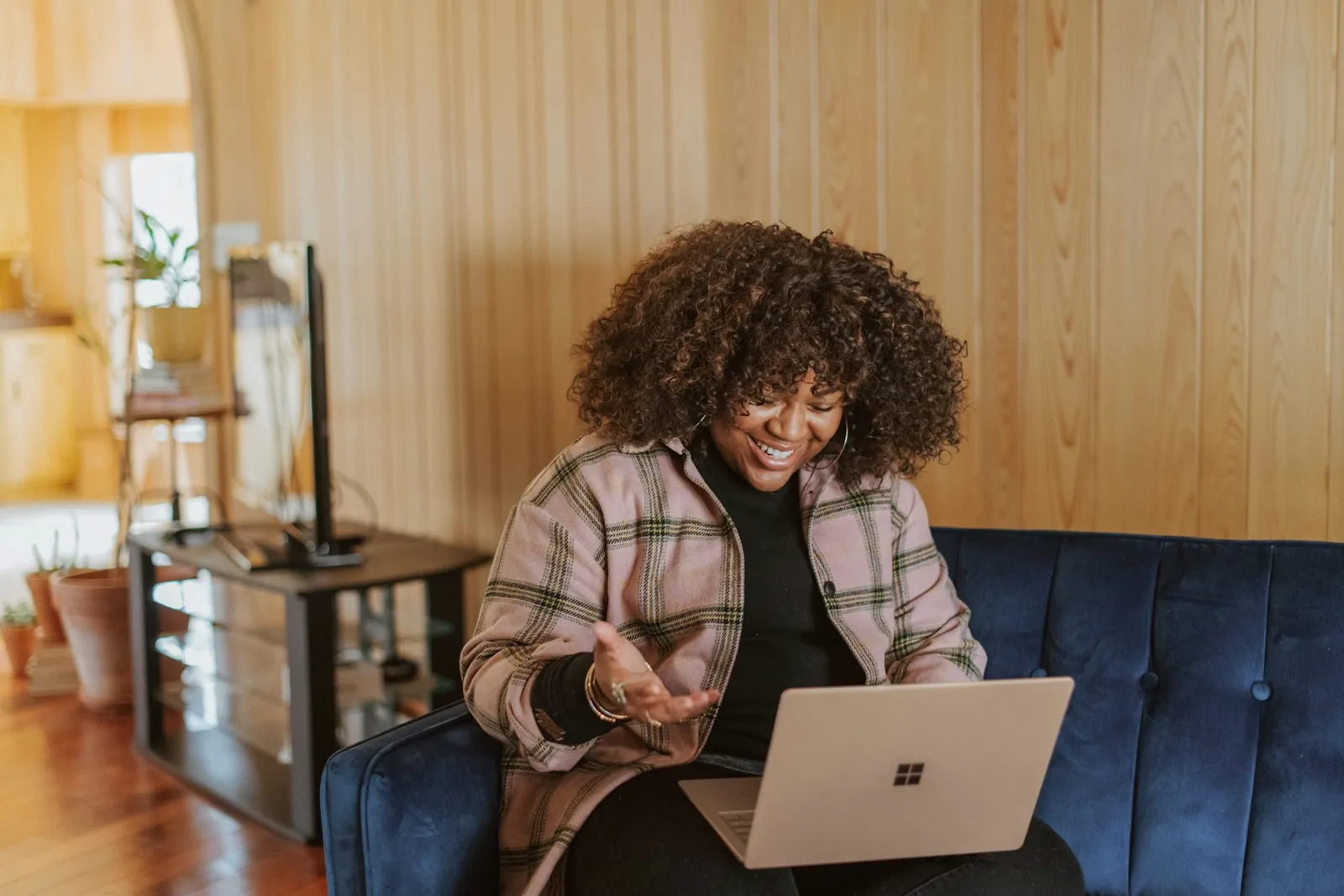 Mujer sonriente comprando desde su laptop en el sofá de su casa